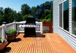 © tab62 - Outdoor BBQ cooker with lid open displaying smoke coming out while on home wooden deck