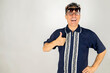 © ideasRojas  - Goofy guy with two pair of glasses on face with a thumb up expression celebrating vacation time. White background and Copy Space.