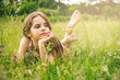 attractive  teenage girl lies on the grass in a clearing on a sunny day