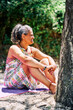 © Nedrofly - Caucasian middle-aged woman smiling sitting in the field