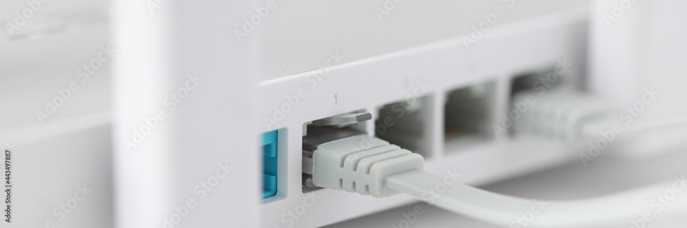 Network cable is plugged into socket of access point closeup - obrazy, fototapety, plakaty 