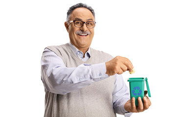 Poster - Mature man throwing waste in a small green plastic bin