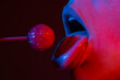 © Volodymyr - Close up lips with lollipop isolated, sexy blowjob, sensual mouth with lipstick eats sweets. Sexy design for women and girls. Beauty lips on neon lights. Night club background.