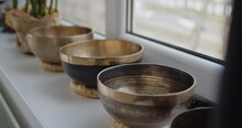 Tibetan Singing Bowls Stand Together On A Windowsill In Yoga Studio. Meditation And Relaxation Concept.
