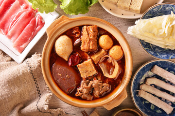 Wall Mural - Personal spicy hot pot with pork, tofu,  mushrooms and green leaves 