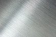 Photograph of brushed metal, or hair line pattern metal. Brushed metal with reflection. Diagonal grain.  High resolution Sharp to the corners.