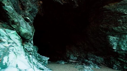 entering into a dark terrifying cave in tintagel castle, cornwall, england in 4k. big rock formation