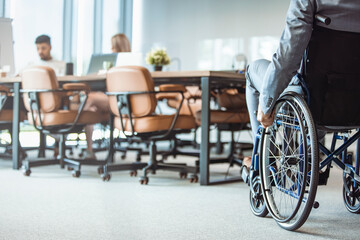 Wall Mural - Close up. Disabled Man on Wheelchair in Office. Disabled Young Man. Man on Wheelchair. Recovery and Healthcare Concepts. Teamwork in Office. Young Workers. Sitting Man. Happy Worker.