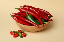Bowl With Red And Green Hot Peppers On Beige Background
