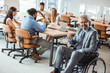 © Dragana Gordic - Portrait of smiling disabled business executive in wheelchair at meeting. Paralyzed man in a wheelchair. Shot of a team of businesspeople having a meeting in a modern office.