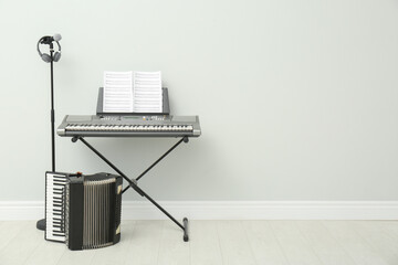 Sticker - Electronic synthesizer, accordion and microphone near white wall indoors, space for text. Musical instruments