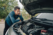 © Charnchai saeheng - Serious man headache and bored side of car breakdown and open bonnet on roadside. Car broken concept.