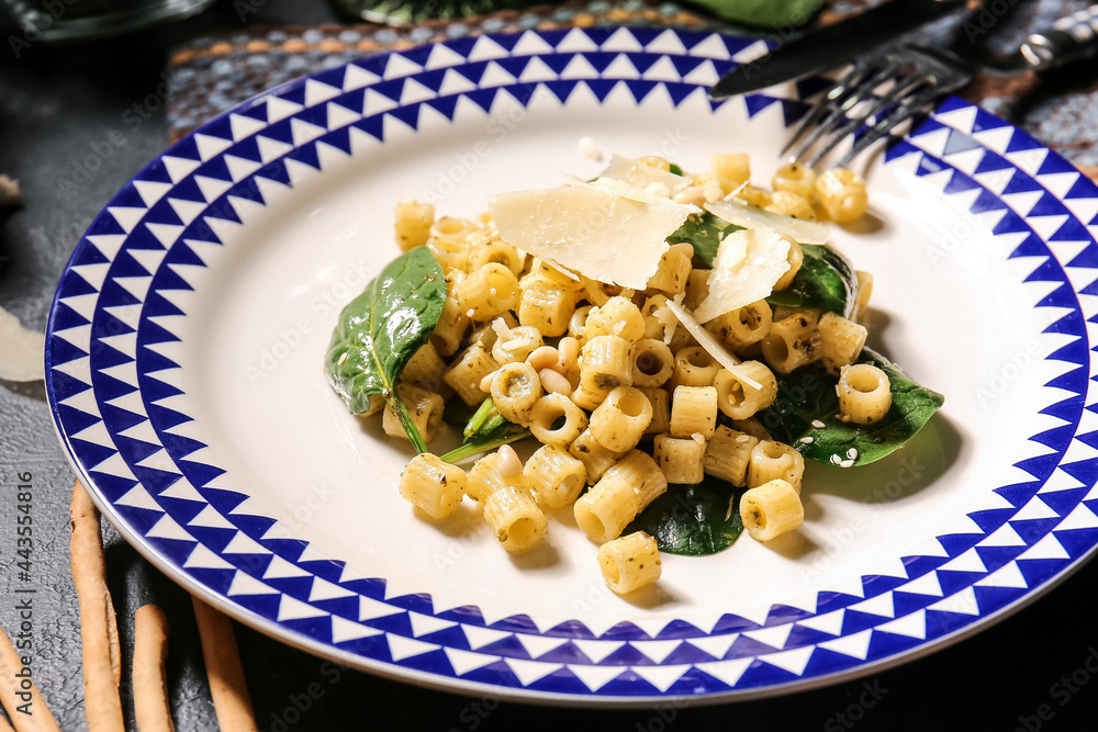 Plate with tasty pasta and spinach on table