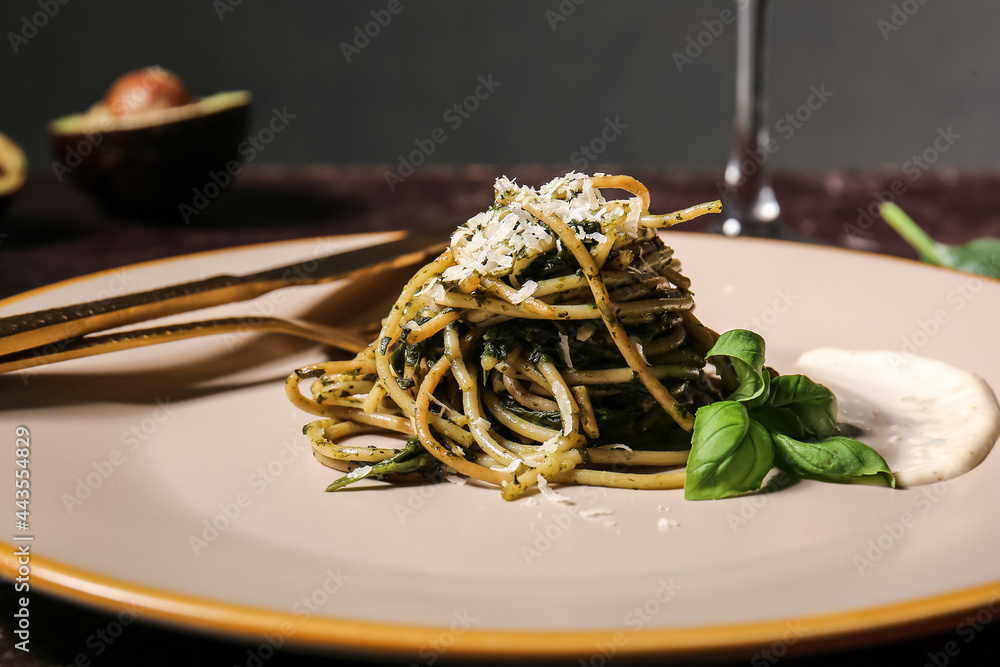 Plate with tasty pasta and spinach on table, closeup
