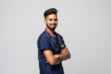 Smiling indian male doctor in white coat with stethoscope over grey background