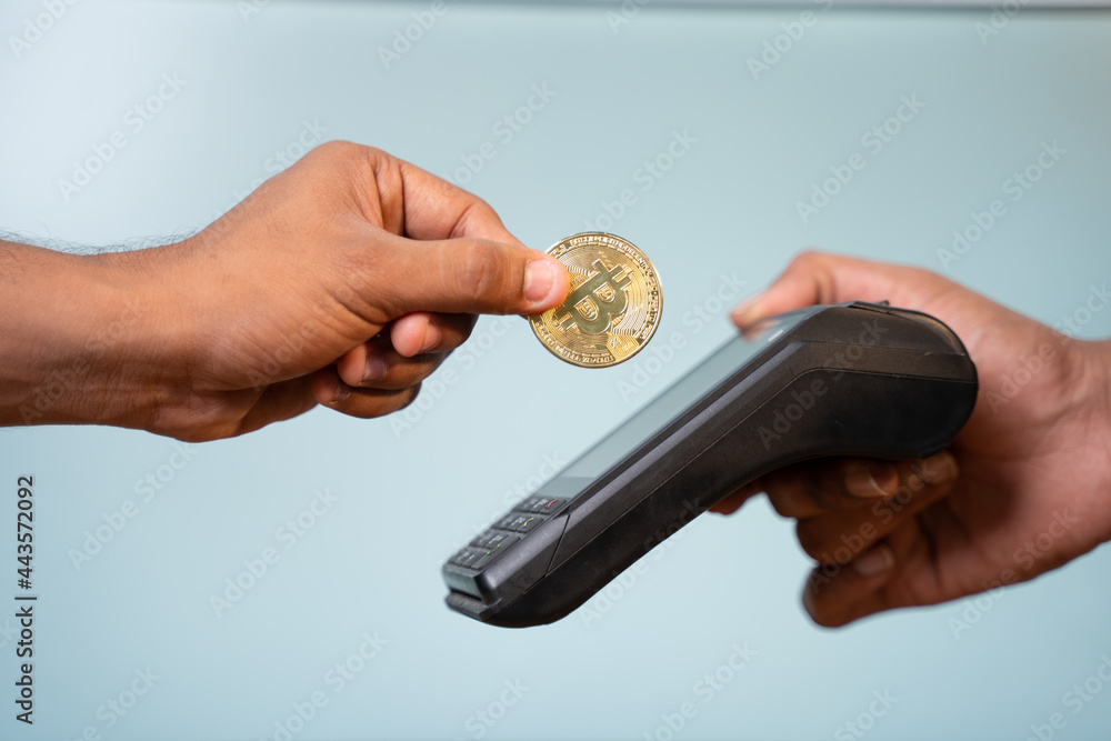 Concept showing of cryptocurrency payment - Hands paying buy placing on swiping payment machine.