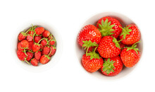 Wild And Garden Strawberries In White Bowls. Fresh, Ripe And Bright Red Fruits Of Alpine Strawberries, Fragaria Vesca, And The Much Larger Garden Strawberries, Fragaria Ananassa. Close-up, Food Photo.