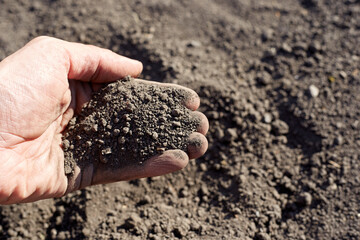 The man in the hand holds the earth a little crumbles, the idea of the photo the soil is our life and nurse