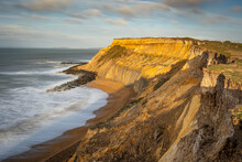 An Eroded Cliff With Distinctive Rocks Lit By The Colour Of The Early Morning Sun On A Bright Winter Day On The South Coast Of England, Uk