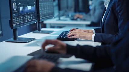 Wall Mural - Close Up Hands Shot of a Technical Support Specialist of Software Engineer Working on a Computer in a Dark Monitoring and Control Room. He types on Keyboard and Moves the Mouse.