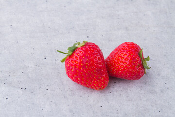 Two red raw fresh strawberries on white background.