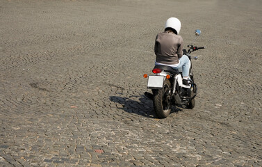 Canvas Print - adult man or woman motorcyclist on sport bike is in the city, rear view.