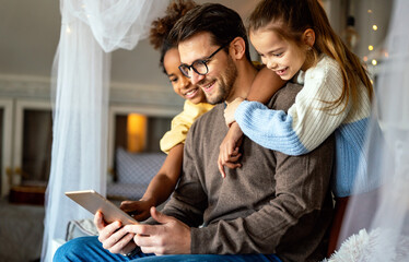 Wall Mural - Happy father with multiethnic children playing with digital tablet at home
