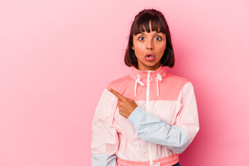 Wall Mural - Young mixed race woman isolated on pink background pointing to the side