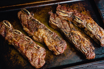 Wall Mural - Grilled Beef Short Ribs on a Sheet Pan: Barbecue flanken beef ribs with a rustic background