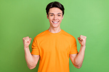 Canvas Print - Photo of positive young happy man good mood winner celebrate lucky guy isolated on green color background