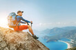 © Soloviova Liudmyla - Young backpacker man sitting on cliff and enjoying the Mediterranean Sea bay at during Lycian Way trekking walk. Famous Likya Yolu Turkish route. Active sporty people vacations concept image