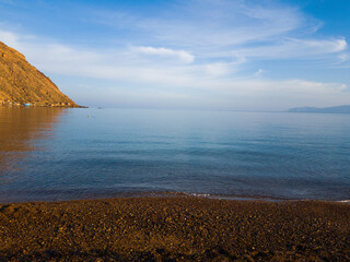 Calm tranquil blue sea under a blue sky, beach and rocks in the coast of Oran