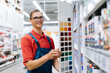 smiling construction store clerk standing near the color palette samples .