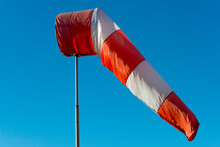 Windsock Against Blue Clear Sky With Sunlight In An Airport In Switzerland.