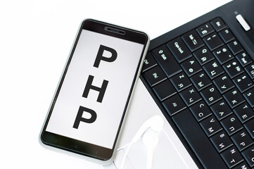 phone on screen letters php next to laptop.