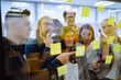 © maxbelchenko - Sharing ideas concepts with papernote writing strategy on wall glass office. Business people meeting at office and use post it notes to share idea. Brainstorming concept. Planning, education, analysis