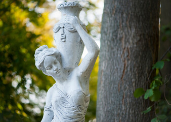 Sticker - sculpture of a girl in the spring park. An old statue in a park of a sensual semi-nude Greek or Italian Renaissance woman with a vase in a city park. sunny day in the summer garden. close-up