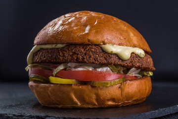 Vegan burger. Falafel and craft bun on a stone tray.