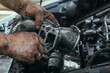 dirty, greasy hands of a man repairing the engine, EGR valve, close up.