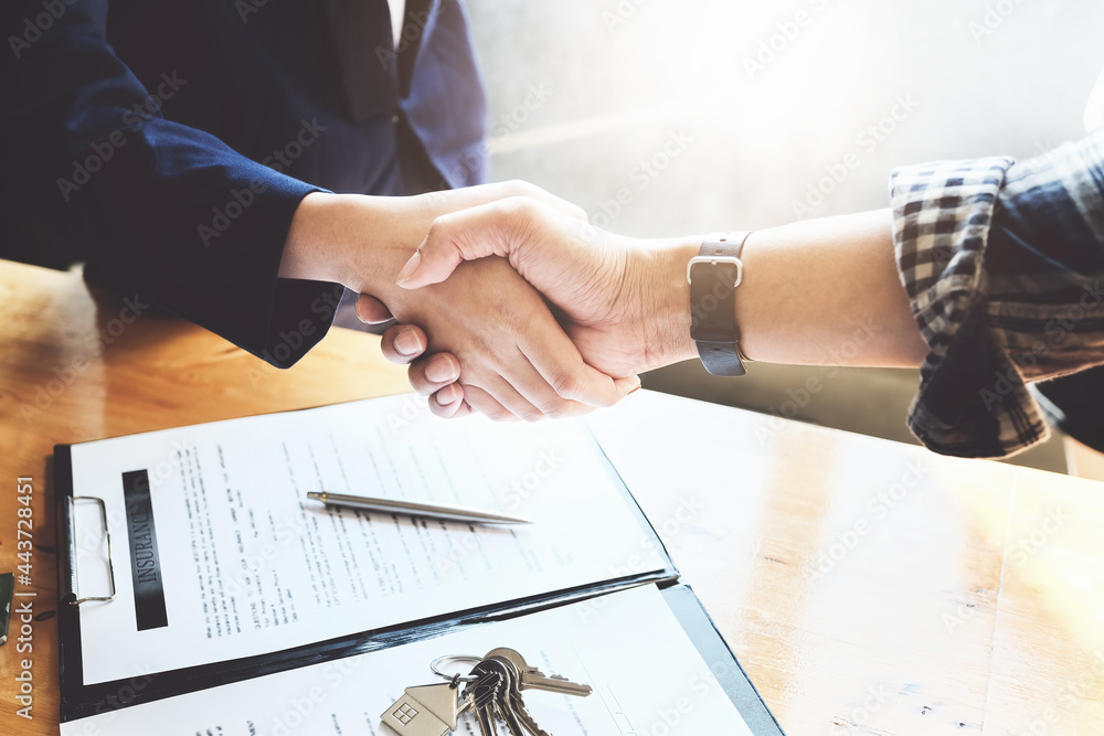 Focus on the congratulatory handshake. The real estate agent agrees to buy the home and hand the keys to the customer at the agent's office. conceptual agreement.