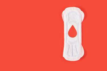 Wall Mural - sanitary pad and a drop of blood from paper on a red background