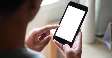 Close up view of male hands using smart phone with modern office blurred background. Blank screen monitor for graphic display montage.