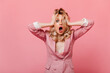 © Look! - Blonde in beautiful pink jacket is holding her head showing off shock