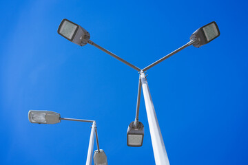 street lamps on a pole against a blue sky