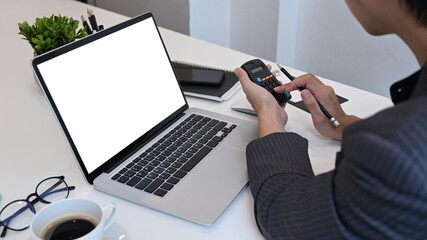 Wall Mural - Businessman using calculator and working with laptop at office.