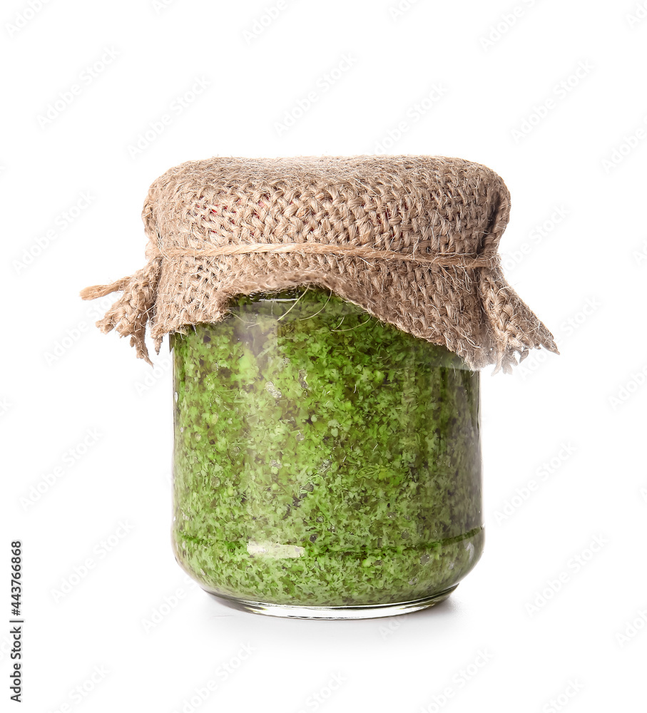 Jar with fresh pesto sauce on white background