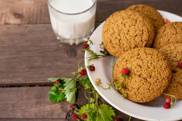 Cookies and milk with strawberry on wooden table with green background. recreation consept in the village