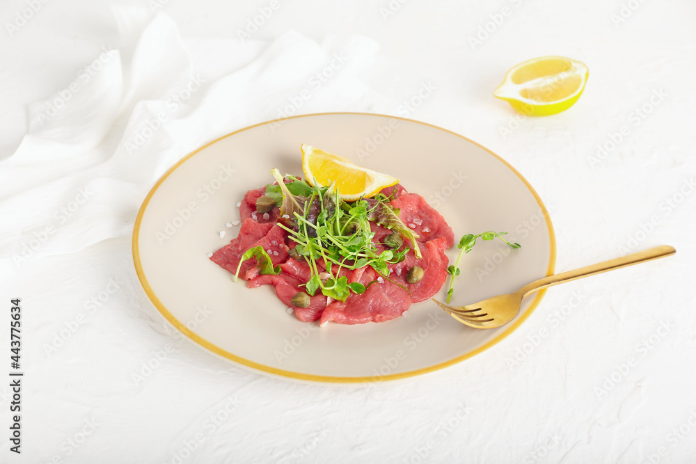 Plate with tasty veal carpaccio on light background