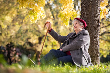 Senior woman relaxing at park during autumn season