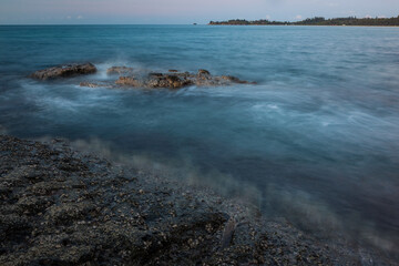 Wall Mural - Waves and rocks shore long exposure